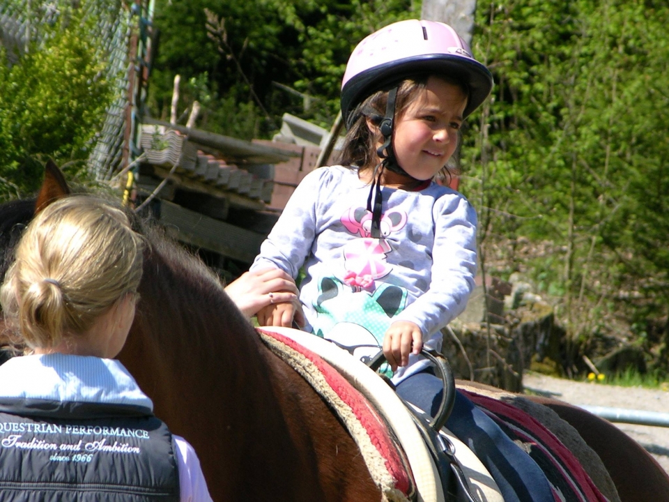 Kind bei der Hippotherapie